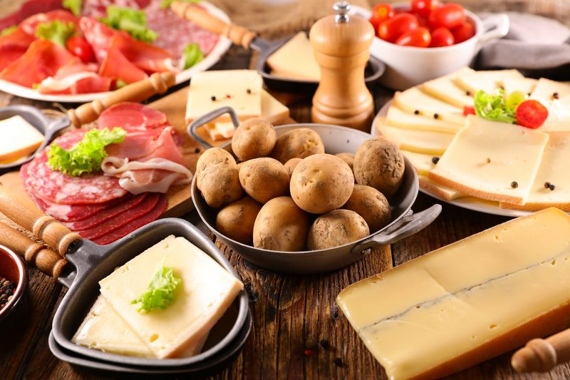 traditional raclette cheese party on wood background