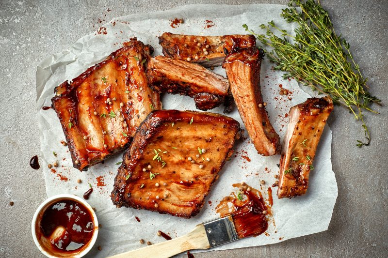 grilled pork ribs on white baking paper, top view