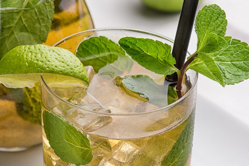 Apple Mojito with Lime, Mint and Cocktail Tube on White Stand with Transparent Decanter.